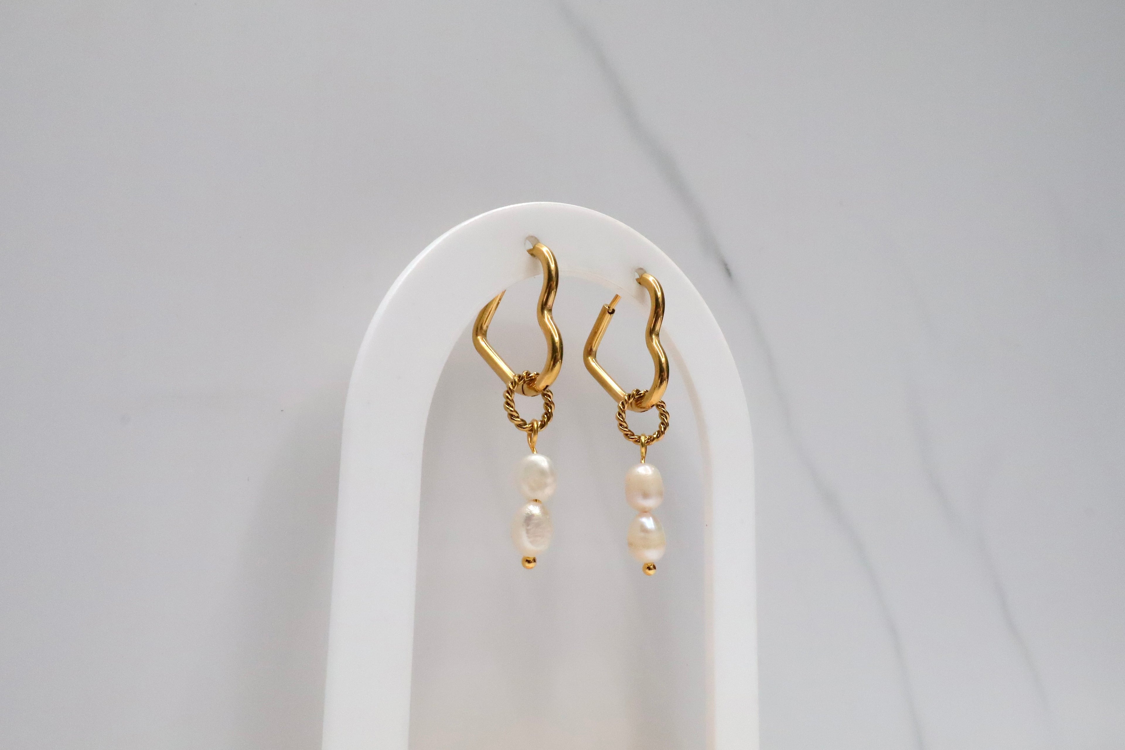 Hartvormige oorringen met hangende parels