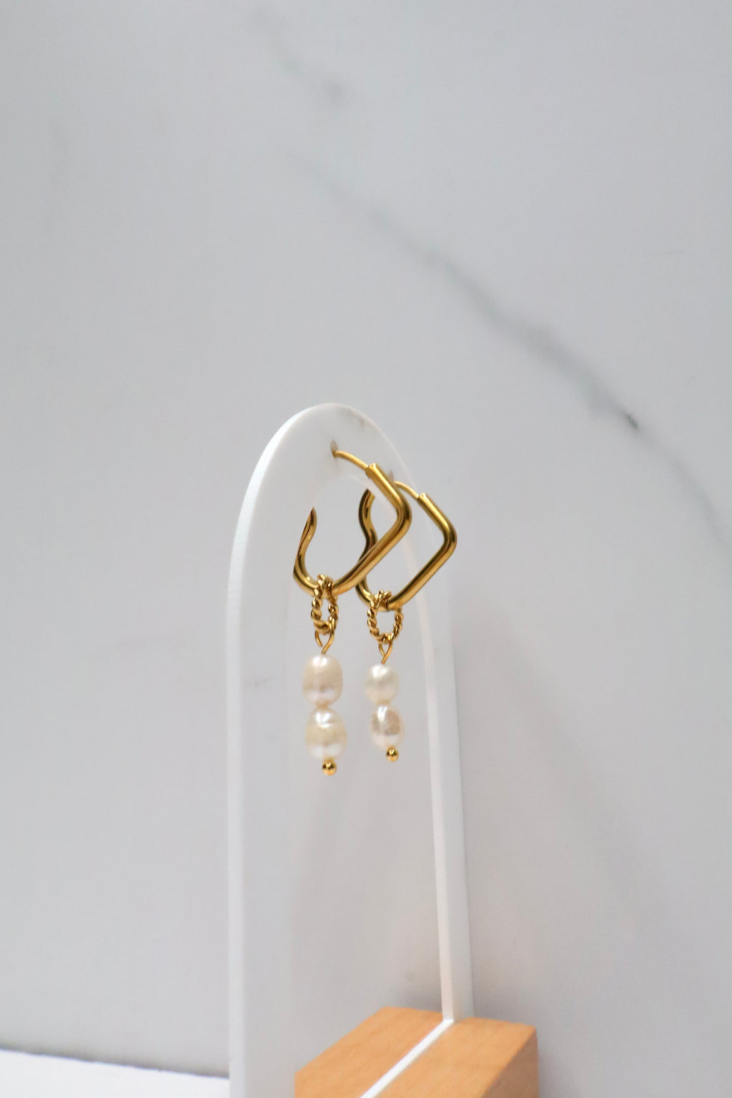 Hartvormige oorringen met hangende parels